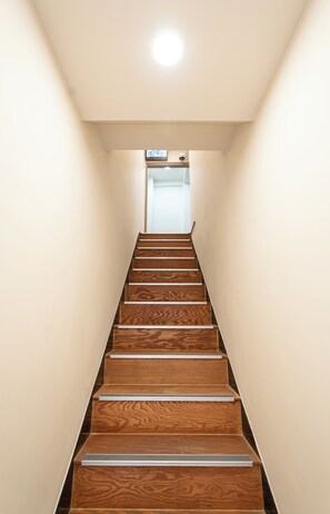 A wooden staircase with a handrail, leading to a door at the top. - Aka Stay Seoul Station (Seoul)