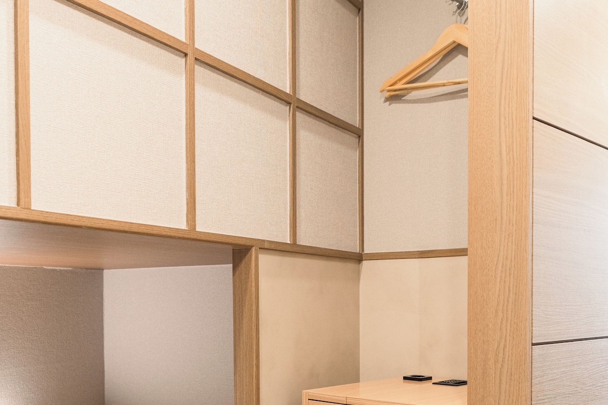 A compact room with a bunk bed, a small desk, and a storage bin.