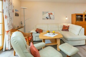 A living room with a sofa set, a coffee table, and a cabinet. - 4.1/T4 holiday home park “Freesenbruch” (Zingst (Ostseeheilbad))