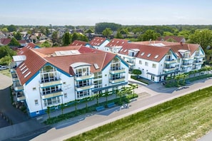 A modern residential building with multiple balconies, a flat roof, and a well-maintained lawn. - Residence on the Beach 1-18 (Zingst (Ostseeheilbad))