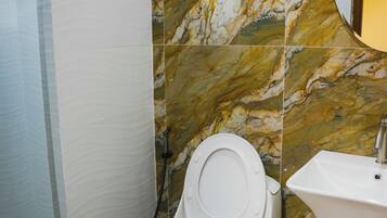 Un bagno con il water, un lavandino e una zona doccia.