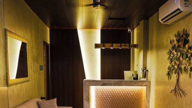 A modern reception area with a sofa, a glass coffee table, and a reception desk.