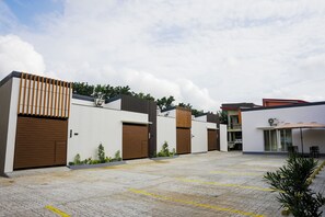 A modern building with large wooden doors, a paved courtyard, and a covered seating area. - Cloudbeds Inn (Laoag)
