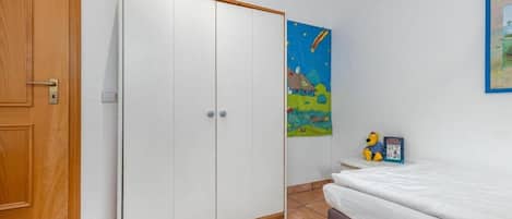 Quarto com cama, guarda-roupa e uma parede decorada com um quadro.