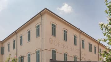 Un edificio con la inscripción 'OPERA BAROLO 1823' en su fachada, con varias ventanas con contraventanas.
