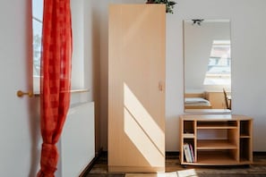 A room with a wooden wardrobe, a mirror, and a small wooden shelf unit. - At the dike, house number 26 (Ostseebad Zingst a Darß)