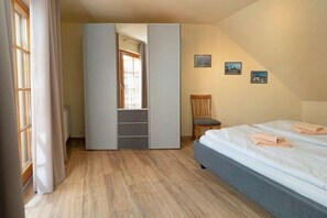 A bedroom with a bed, a wardrobe, a chair, and a small table. - 4.6/T1 holiday home park “Freesenbruch” (Zingst (Ostseeheilbad))