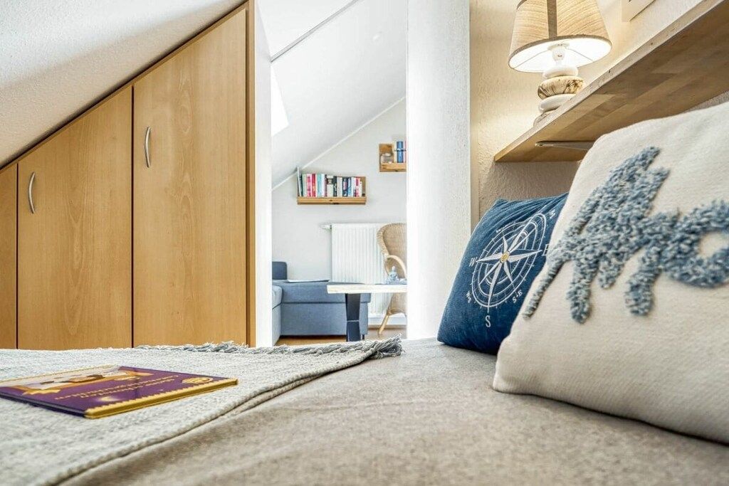 A cozy room with a sofa, a lamp, and a bookshelf.