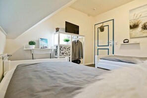 A bedroom with a bed, a wardrobe, a desk, and a door. - 11a/T6 holiday home park “Freesenbruch” (Zingst (Ostseeheilbad))