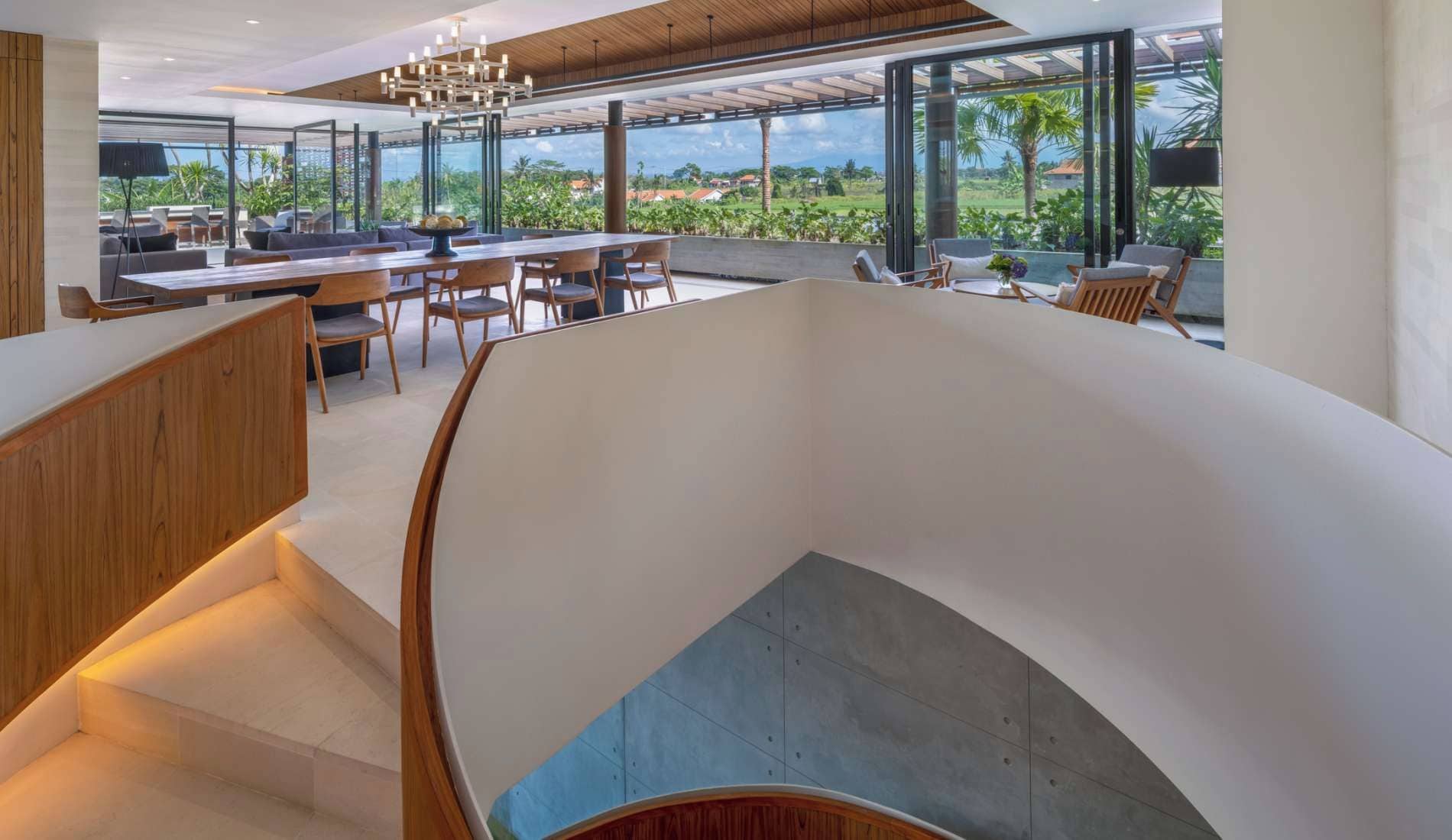 Un intérieur moderne comprenant un coin repas, un escalier et une vue sur l’extérieur.