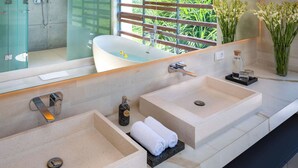 A modern bathroom with two sinks, a bathtub, and a large mirror. - Villa Babadan (Badung)
