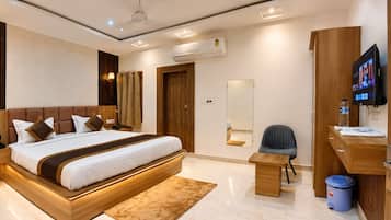 Une chambre d’hôtel moderne dotée d’un grand lit, d’une table de chevet, d’un bureau avec une chaise, d’une télévision et d’une salle de bain avec un miroir.