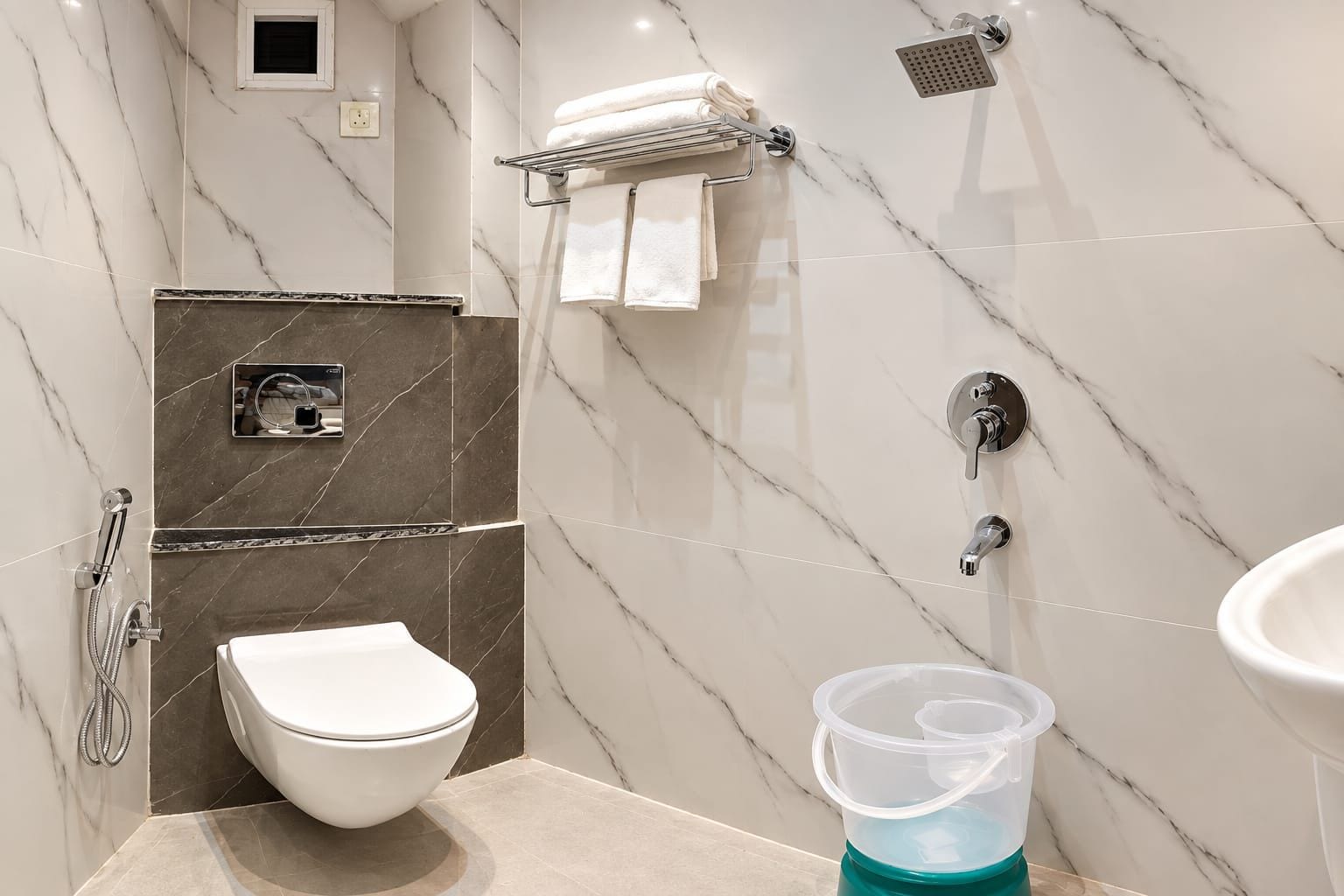 A modern bathroom with a toilet, shower, and sink.