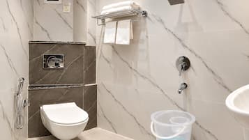 A modern bathroom with a toilet, shower, and sink.