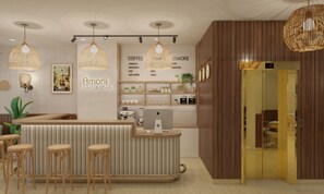 A reception area with a counter, bar stools, hanging lights, a coffee station, and a wall with a clock and a sign for Amorii Hotel & Café. - Amorii Hotel Phu Quoc (Phu Quoc)