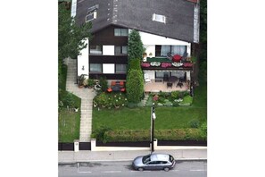 A two-story residential building with a balcony, a car parked in front, and a well-maintained lawn. - "Vienna Woods" Am Wiesengrund (Wien)