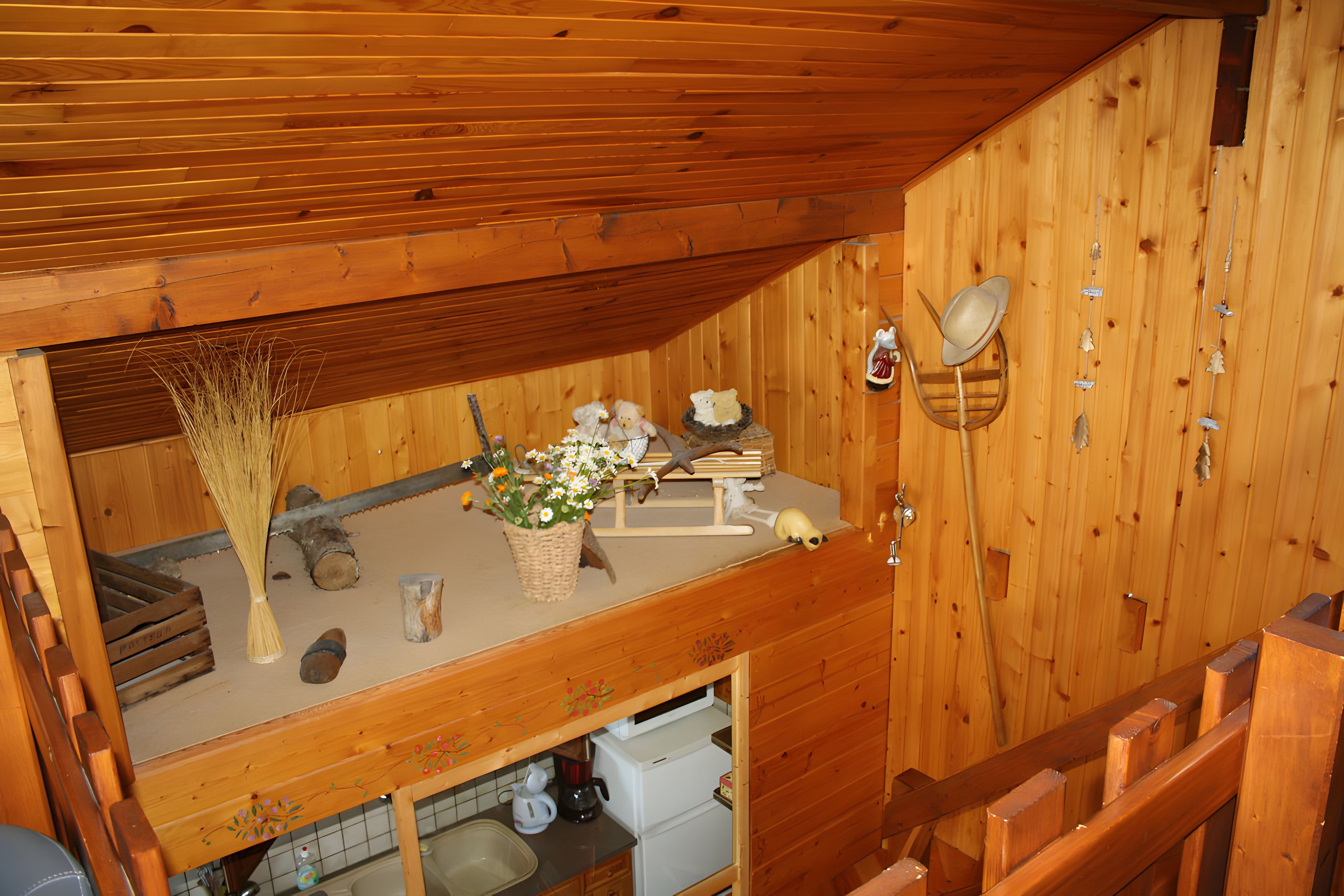 Un interior de madera con cocina, una mesa de comedor y sillas, y un estante con objetos decorativos.