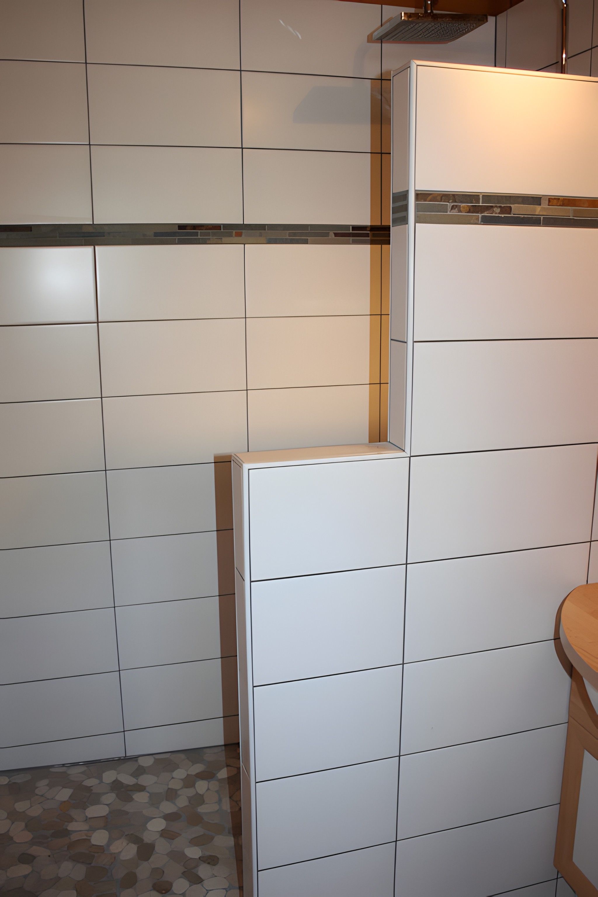A bathroom with white tiled walls and a tiled floor.