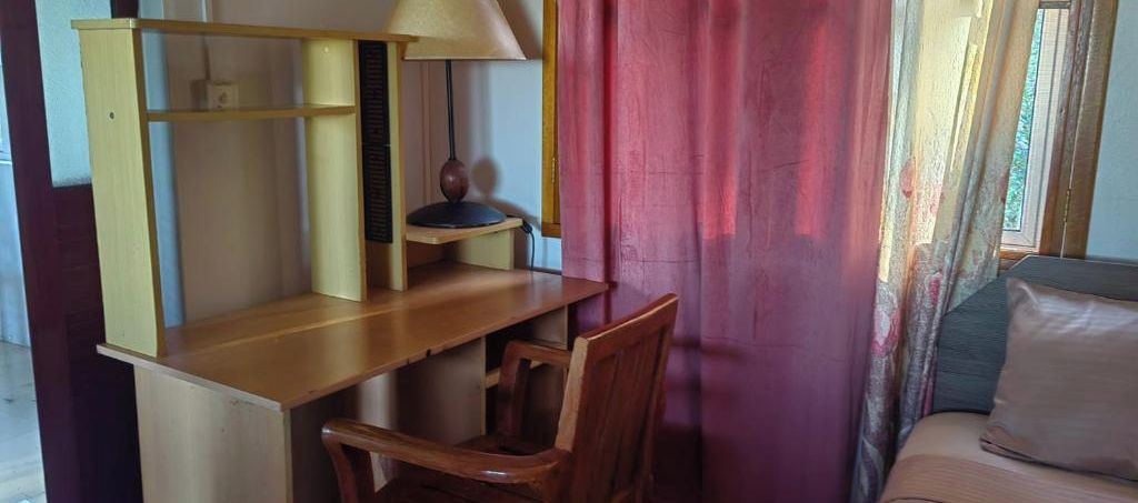 A room with a desk, chair, and a bed.