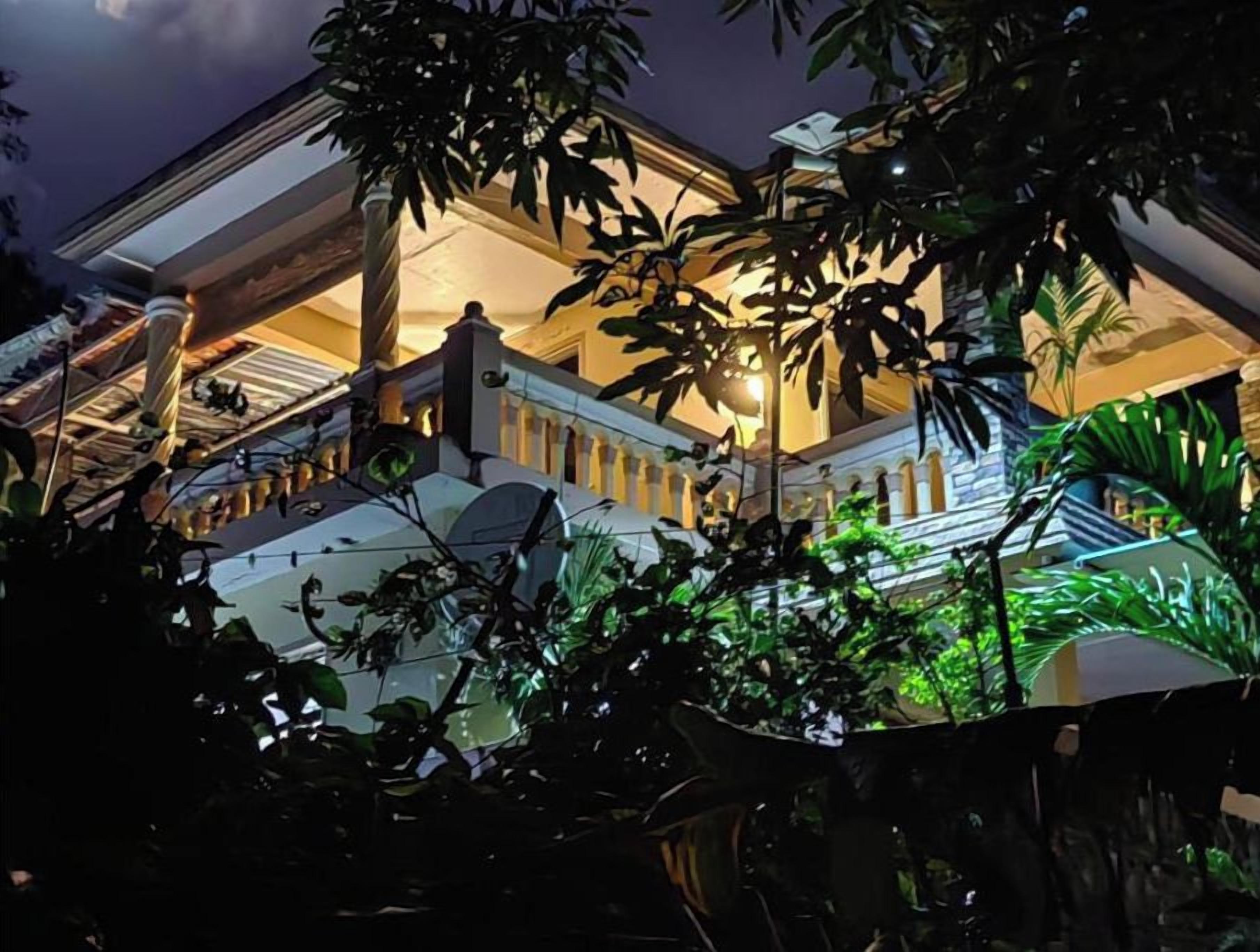 Un bâtiment doté d’un espace extérieur abrité, de colonnes et de plantes en pot.