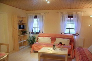 A cozy room with a bed, a table with candles, and a shelf with plants. - Holiday apartment with 1 bedroom (Bad Schandau)