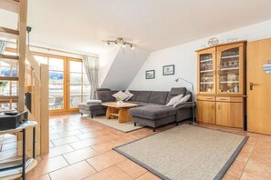Een moderne woonkamer met een bank, bijzettafeltje en kast.