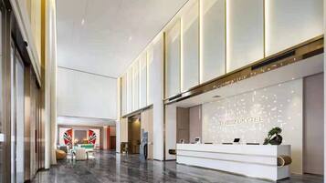 A modern hotel lobby with a reception desk, seating area, and a large window.