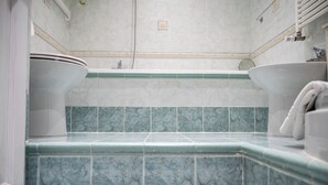 Ein Badezimmer mit Toilette, Bidet und Badewanne.