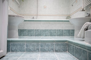 A bathroom with a toilet, bidet, and bathtub. - Vrbo Property (Roma)