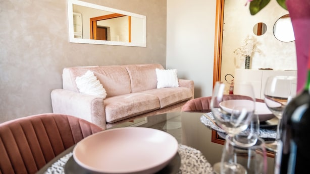 Ein modernes Wohnzimmer mit einer Couch, einem Esstisch, Stühlen und einem Couchtisch aus Glas.