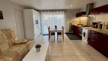 A modern apartment with a dining area, kitchen, and living space.
