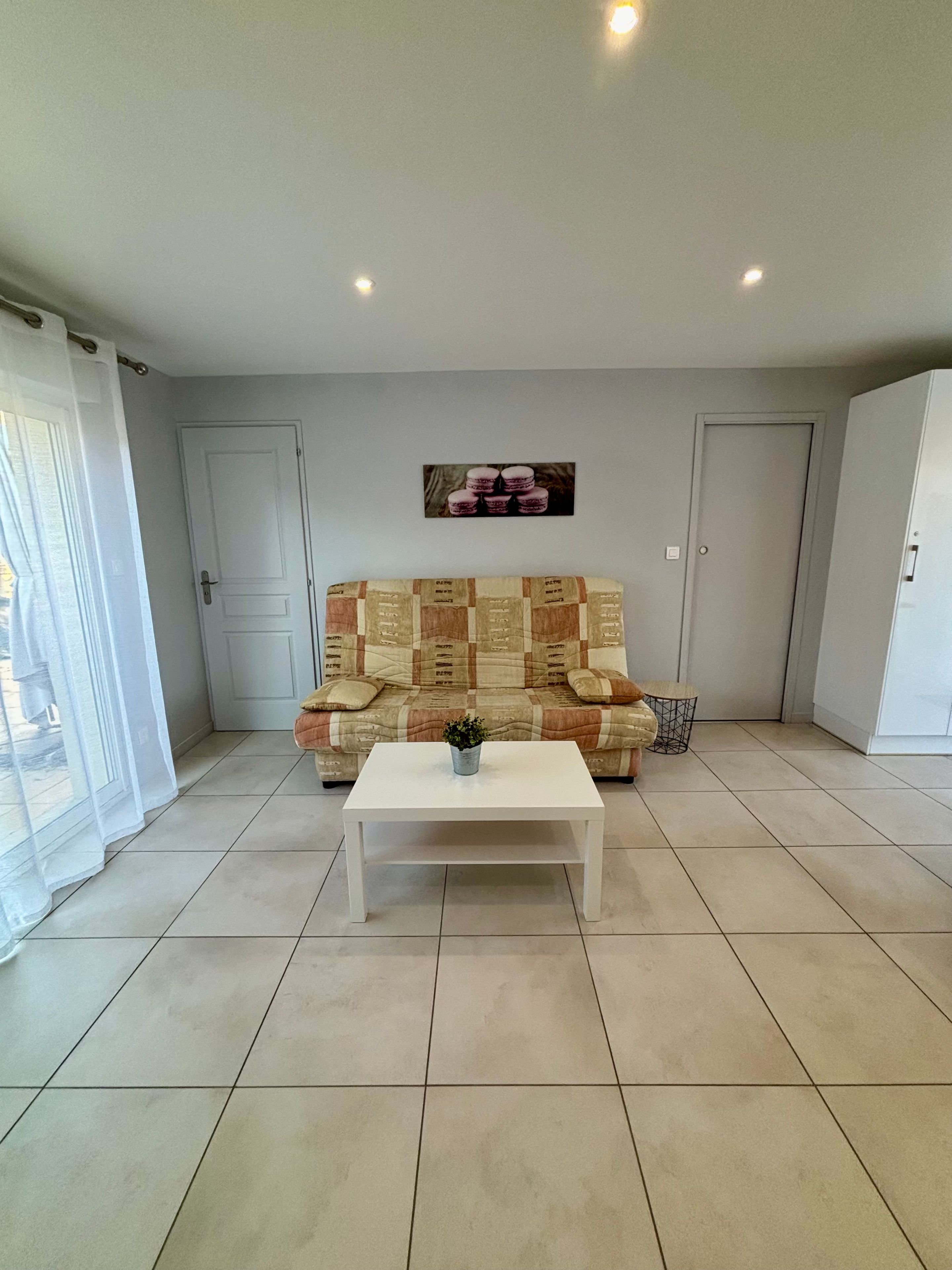 A living room with a sofa, a coffee table, and a wall-mounted picture.