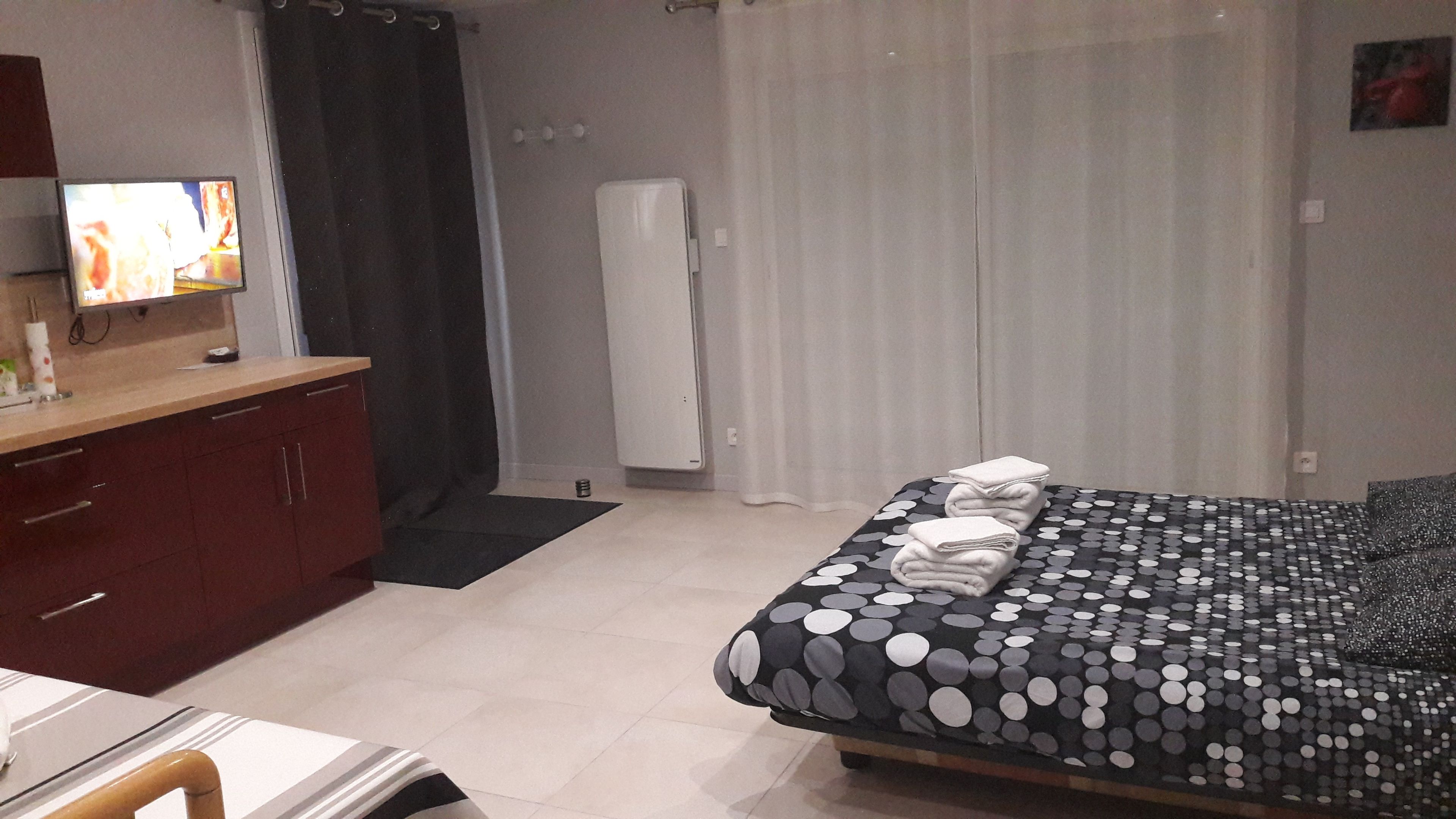 Une chambre à coucher avec un lit, un bureau et un téléviseur.