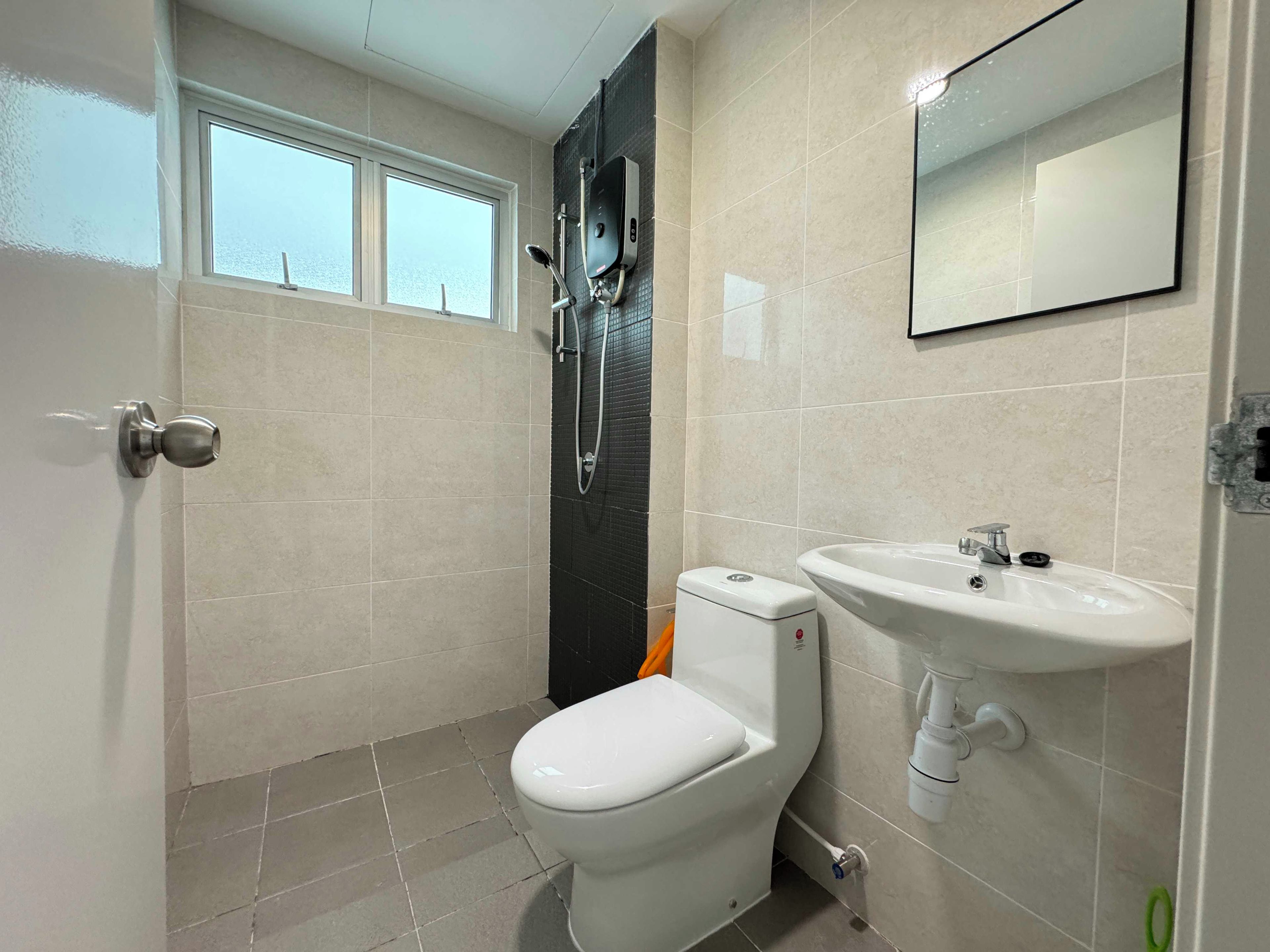 A bathroom with a toilet, sink, and shower.