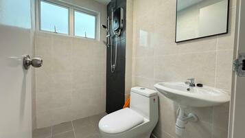 A bathroom with a toilet, sink, and shower.