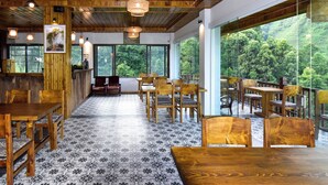 A restaurant with wooden furniture, large windows, and a patterned floor. - MAISON DE LAO CHAI (Sa Pa)