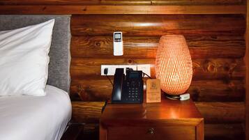 Une table de chevet en bois avec une lampe, un téléphone et un symbole Wi-Fi.