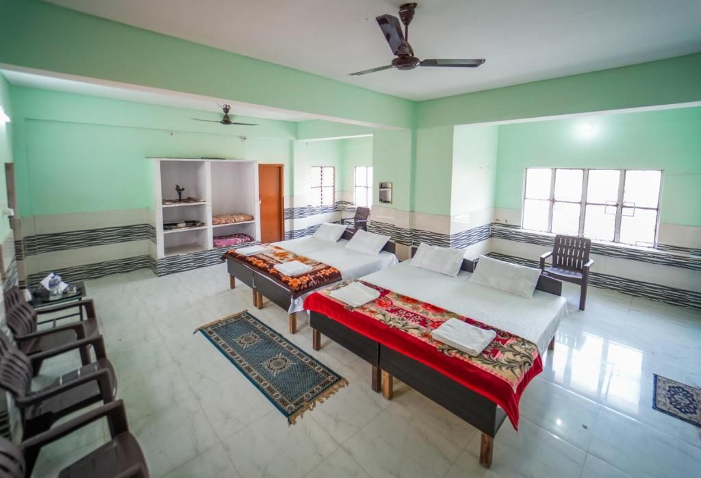 A hotel room with two beds, a ceiling fan, and a window.