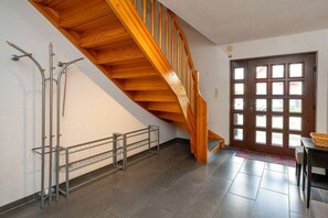 A staircase with wooden steps and a metal railing, leading to a door with a grid pattern. - Holiday home with 1 bedroom (Zingst (Ostseeheilbad))