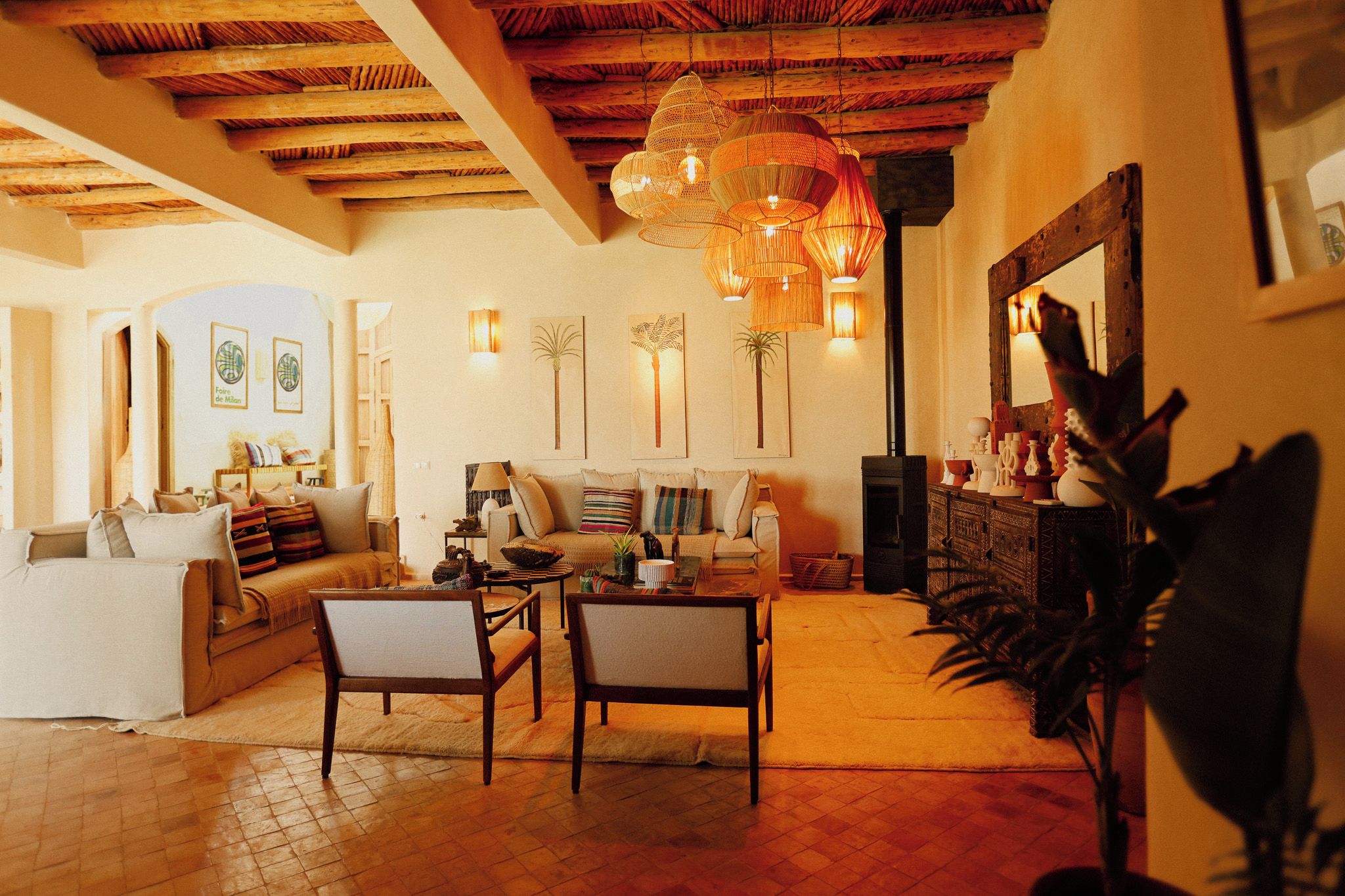 Una sala de estar acogedora con techo de madera, un sofá, una mesa de centro y un comedor con sillas.