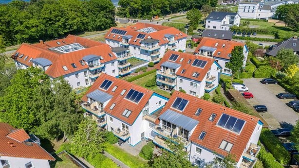 A residential area with multiple two-story houses featuring red-tiled roofs and solar panels. - Residence Am Strand 1-16 (Seeheilbad Zingst)