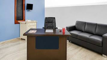 Een moderne kantoorruimte met een bureau, stoel en bank.