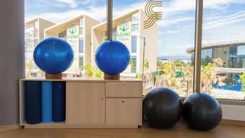 A room with exercise balls, a wooden cabinet, and a view of a building with 'LUMI VILLA' signage.