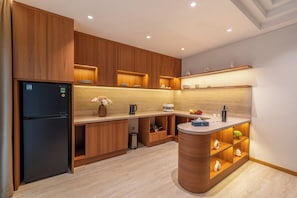 Una cocina moderna con armarios de madera, refrigerador empotrado y una isla central con pileta.