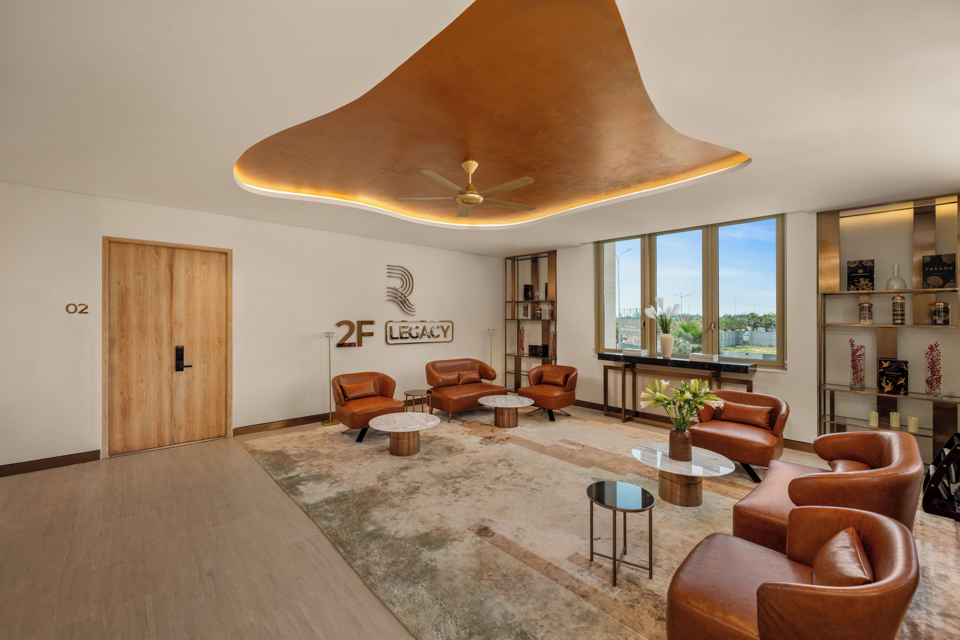 A modern lounge area with leather sofas, a coffee table, and a bookshelf.