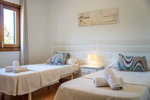 A hotel room with two beds, each with a white bedspread and a rolled towel. There is a nightstand with a lamp between the beds, and a window on the left side. - Finca with pool Son Manyo 2 Petit in Sa Pobla (Sa Pobla)
