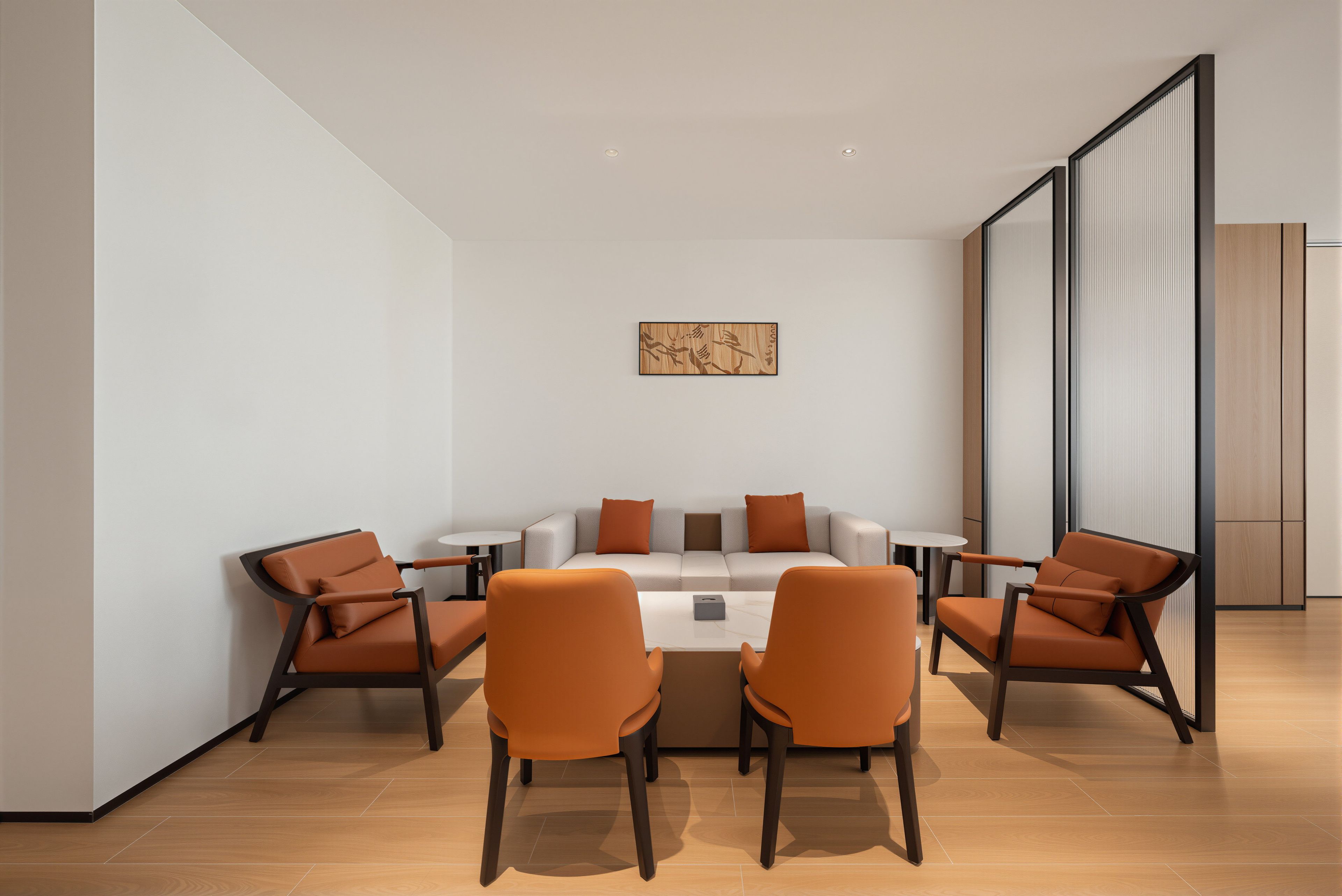 A modern meeting room with a round table, six chairs, and a minimalist decor.