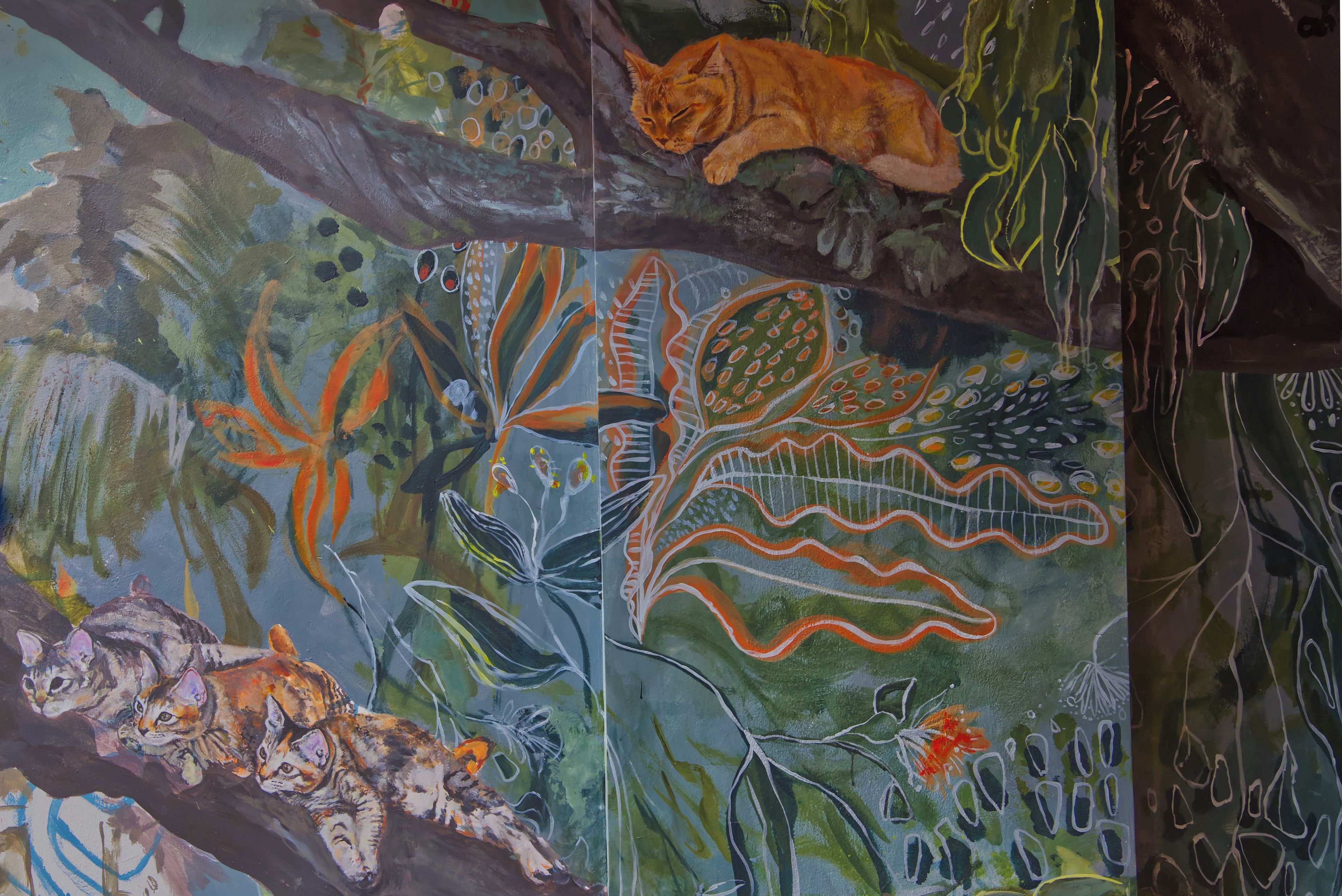 Een muurschildering met verschillende dieren en abstracte patronen.