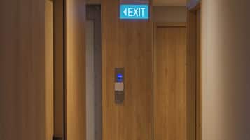 A hallway with a wooden door and an EXIT sign above it.