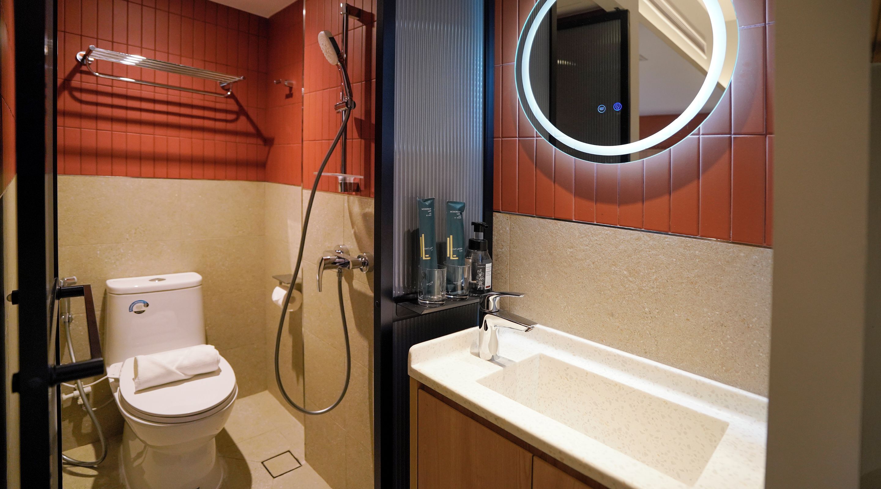 Une salle de bain comprenant des toilettes, une douche, un lavabo et un miroir.